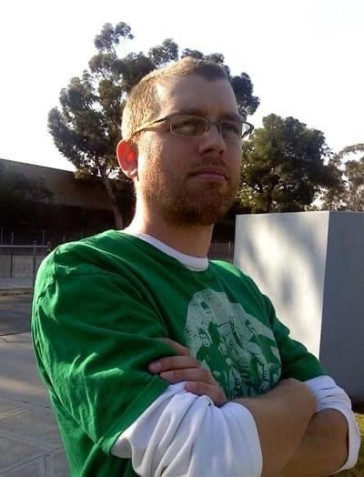 A sad shell of a human pretending very badly and painfully to be a man, with a short buzzzcut hairstyle and a very stubble-filled face, standing outside with arms crossed and FACING AWAY FROM THE LIGHTING? Girl, come on.