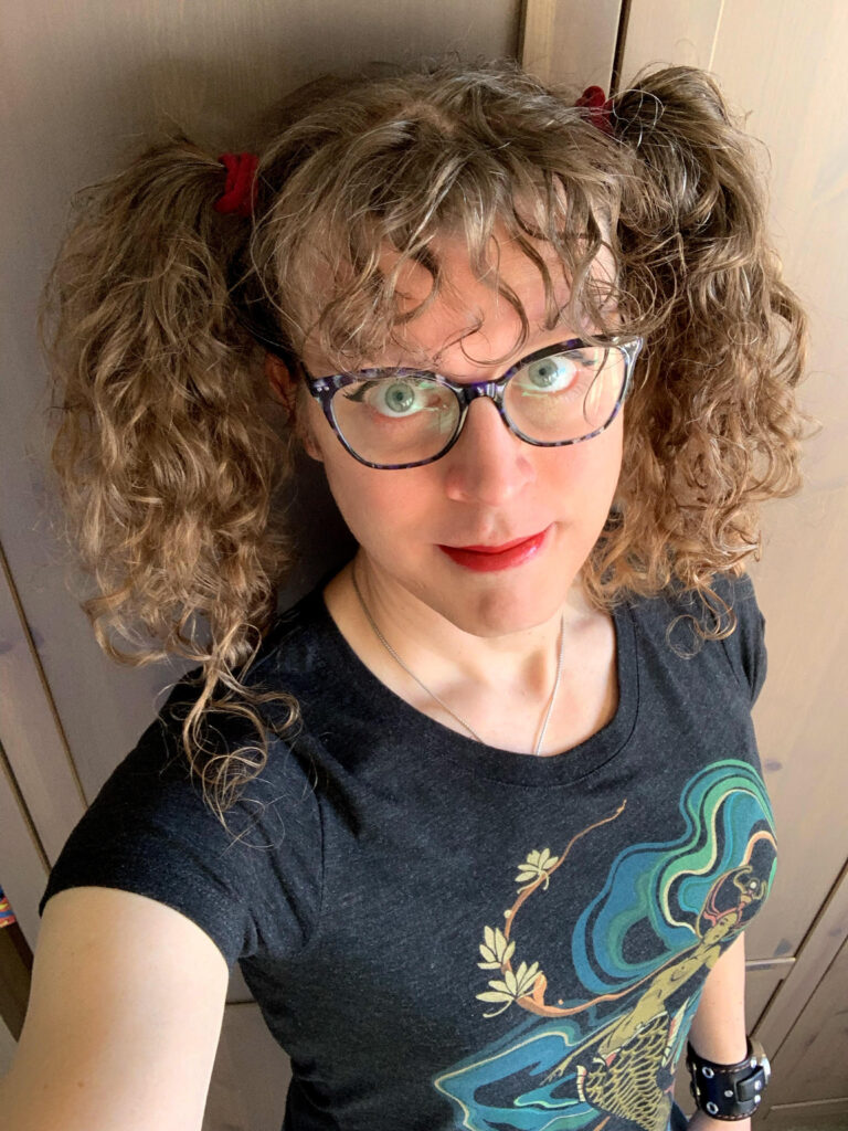 Me in a mermaid t-shirt with my long brown curly hair up in pigtails