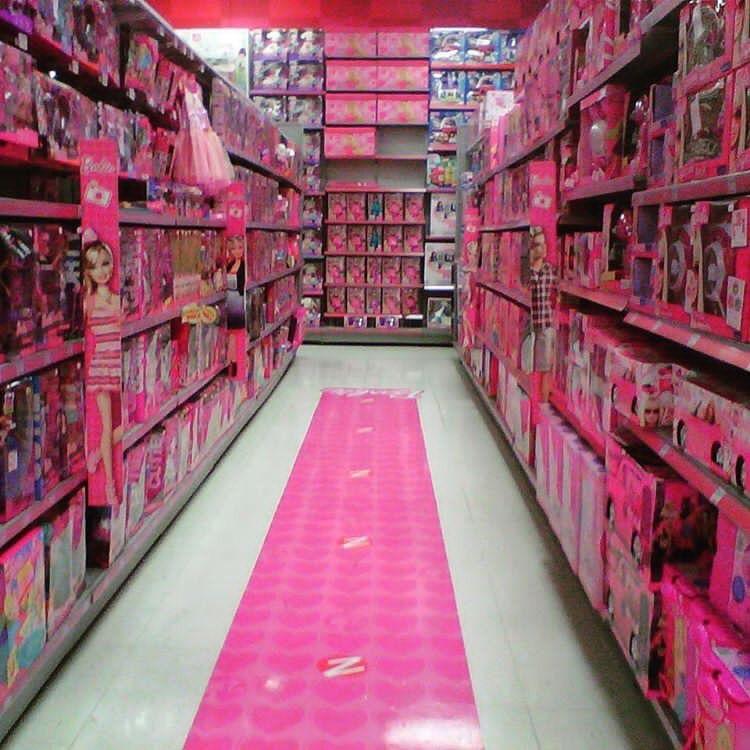 A photo of the searing pink aisle of Barbie and “girl” toys in a store