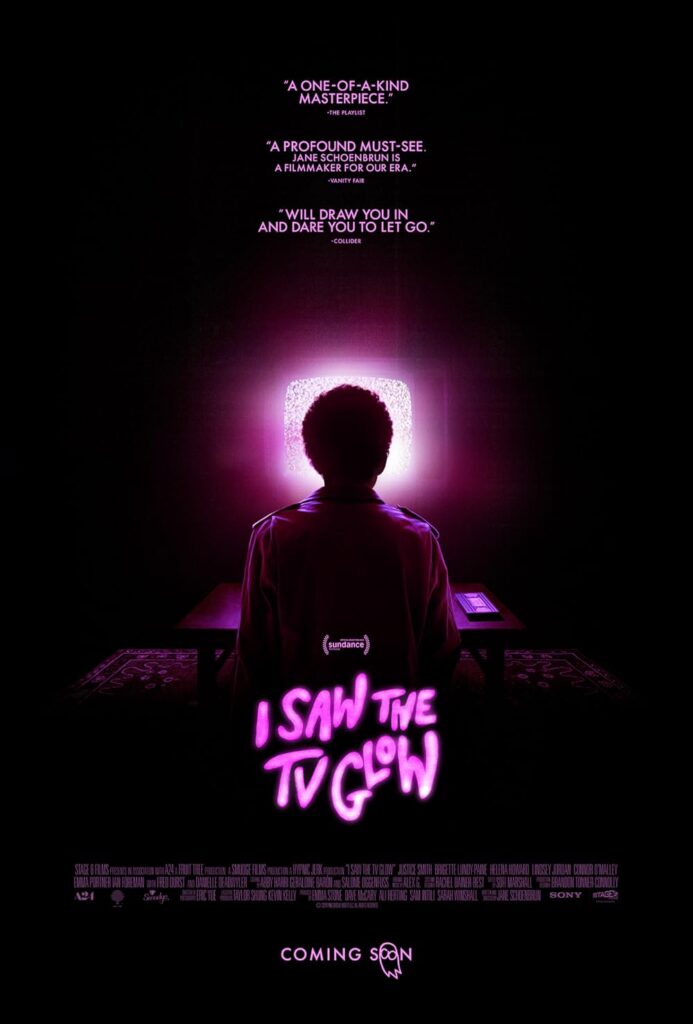 I Saw the TV Glow promo poster, showing Owen from behind, sitting in front of a TV with a screen that’s glowing pink.